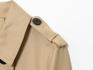 Gros plan détaillé montrant l'épaulette et la texture d'un trench-coat imperméable de couleur kaki