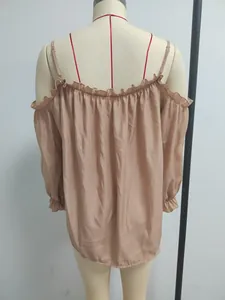 Detailed back view of an apricot off-the-shoulder blouse with ruffled trim on a mannequin