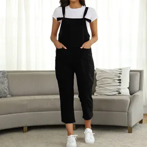 Detailed front view of women's casual black overalls jumpsuit over a white T-shirt