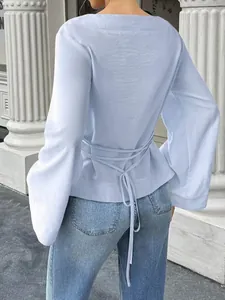 Back view of light blue flare sleeve top featuring a chic waist tie detail.