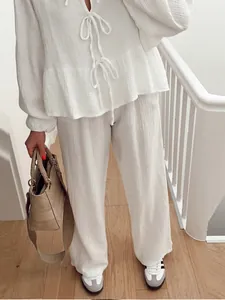 Macro detail of white crinkle fabric lounge set featuring tie-front ruffle hem top
