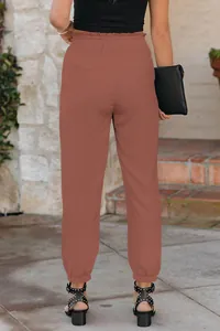 Detailed back view of women's high-waisted tapered cuffed casual trousers in terracotta red