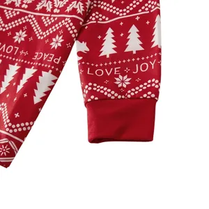 Nahaufnahme eines roten Weihnachtsschlafanzug-Ärmels mit PEACE-LOVE-JOY-Aufdruck