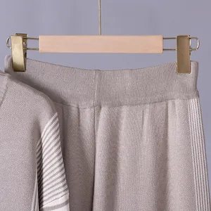 Detailed macro shot showing the fine knit texture and striped patterns of the beige set.