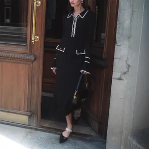 French chic black knitted midi dress with white contrast piping and ruffled cuffs