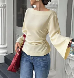Detailed view of the flared sleeves and cinched waist on a boat neck beige top.