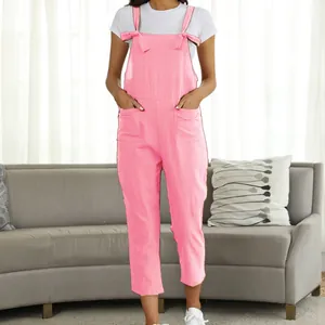 Full body view of women's casual pink cotton overalls over a white t-shirt