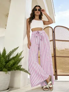 Detail view showing the loose fit of women's pink striped wide-leg pants on a model