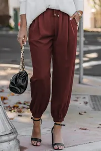 Detail view of women's burgundy high waist drawstring joggers with elastic cuffs.