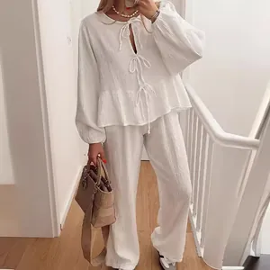 Elegant white two-piece set with lantern sleeve tie-front blouse and wide-leg pants