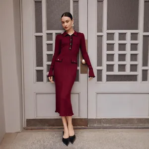 Elegant burgundy ribbed knit midi dress with ruffled edges and black piping detail.