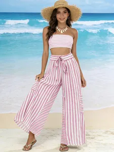 Detailed view of pink striped wide-leg pants and matching tube top on beach.