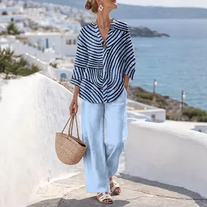 Blau gestreiftes V-Ausschnitt Oberteil und hellblaue gerade Hose für den Strandlook.