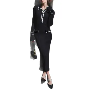 Elegant black knit midi dress with white trim and ruffled cuffs for a chic autumn look.