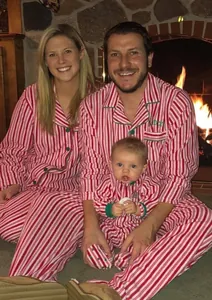 Conjunto de pijamas navideños familiares con clásicas rayas rojas y blancas en casa
