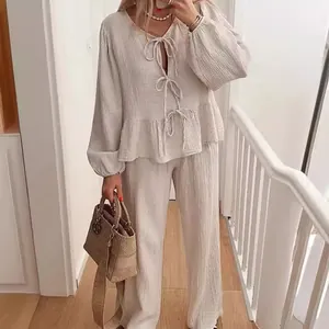 Minimalist beige two-piece set featuring tie-front lantern sleeve top and wide-leg pants.
