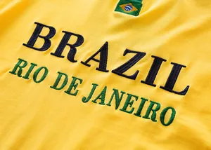 Primer plano del bordado 'BRAZIL' en un polo de fútbol de algodón amarillo