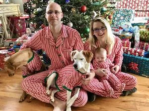 Familia y mascotas con pijamas navideños a rayas rojas y blancas a juego
