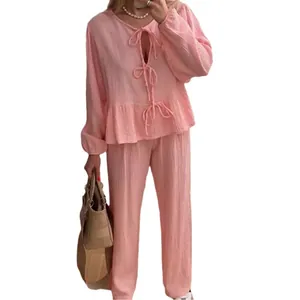 Elegant pink two-piece outfit featuring lantern sleeve tie-front top and matching trousers