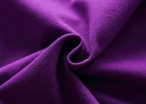 Macro shot showing the purple pique knit texture and breathable weave of the polo shirt.