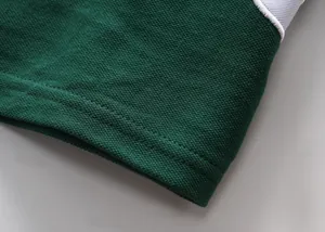 Dettaglio macro di una polo in cotone piqué verde con cuciture a doppio ago rifinite