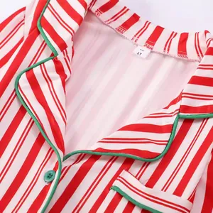 Detalle de pijama de Navidad a rayas rojas y blancas para niños con etiqueta talla 3T