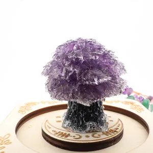 Detailed view of a purple amethyst crushed stone crystal tree on a wooden base.