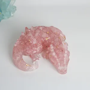 Macro detail view of pink resin dragon figurine with rose quartz chips and gold flakes