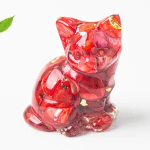 Dettaglio ravvicinato di statuetta a forma di gatto seduto in resina con cristalli rossi