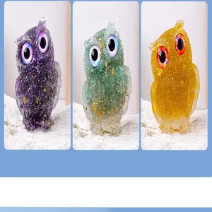 Macro view of three owl figurines showcasing crystal gravel textures in purple, green, and yellow