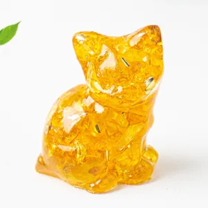 Dettaglio di una statuina a forma di gatto in resina gialla con scaglie di foglia d'oro