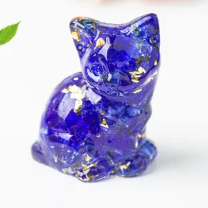 Dettaglio macro di statuetta di gatto in resina blu con foglia d'oro e cristallo