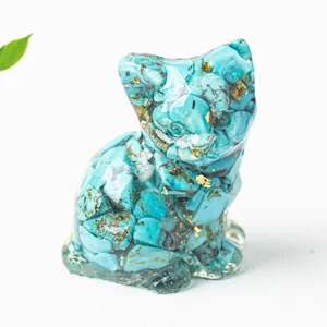Dettaglio di statuetta di gatto in resina e cristalli turchesi con accenti in foglia oro