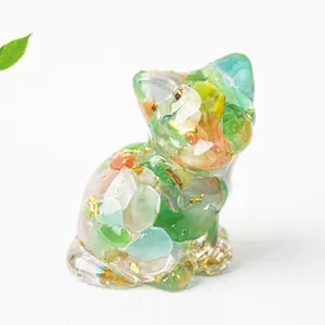 Dettaglio di statuetta di gatto in resina con cristalli naturali e foglie d'oro