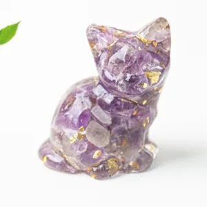 Dettaglio macro di una statuina a forma di gatto in cristallo di ametista con foglia d'oro