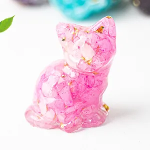 Macro di un gatto in resina rosa con frammenti di cristallo naturale e scaglie d'oro