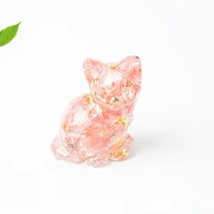Vista macro di una simpatica statuina di gatto in pietra di cristallo rosa e oro