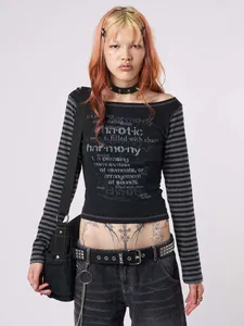 Model wearing black off-shoulder long sleeve T-shirt with striped sleeves and graphic text