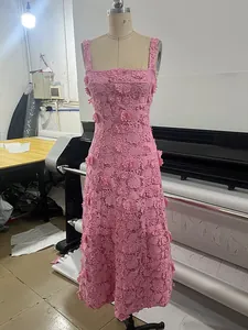 Vista detallada de un elegante vestido midi de encaje rosa con flores 3D en un maniquí de costura