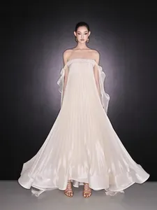 Full-length view of an elegant pleated off-the-shoulder cream evening gown.
