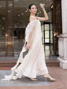 Elegant white off-the-shoulder pleated dress with flowing streamers and braided detail.