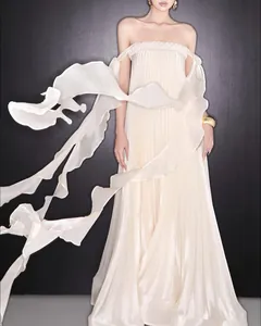 Detailed view of the pleated cream strapless dress with elegant flowing streamers