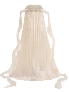 Detailed view of cream pleated strapless maxi dress with flowing silk-like streamers.