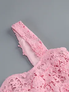 Primer plano detallado de encaje floral rosa y tirantes en un elegante vestido sin mangas.