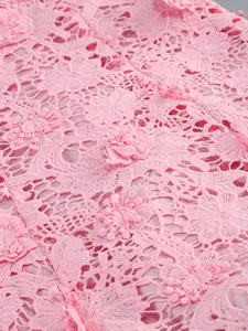 Detalle de primer plano de tela de encaje floral rosa con apliques de flores en 3D