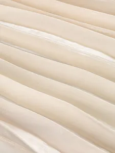 Close-up view showing the fine texture and shimmer of champagne pleated chiffon fabric