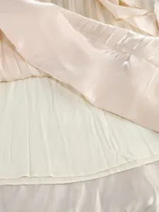 Close-up of the shimmering pleated fabric and soft lining of an elegant maxi dress