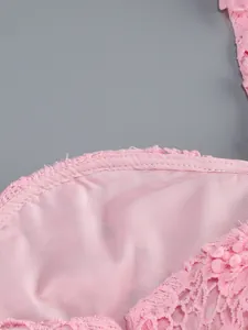Primer plano del forro interior y las costuras de precisión de un vestido rosa de encaje.