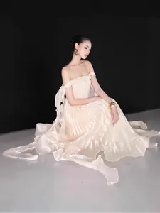 Elegant cream off-the-shoulder pleated maxi evening gown with delicate ribbon details