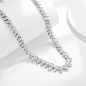 Macro view of pear-shaped moissanite stones on a silver-plated necklace chain.